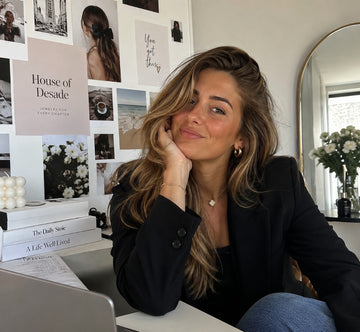 Woman wearing House of Desade jewelry at a desk